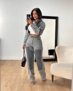 woman in grey denim patchwork jacket and matching jeans taking mirror selfie