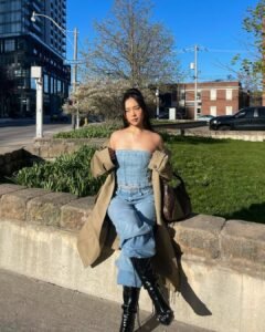 woman wearing denim tube top and matching jeans with tan trench coat