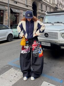 person wearing oversized patterned pants and a blue and white fleece jacket on a street