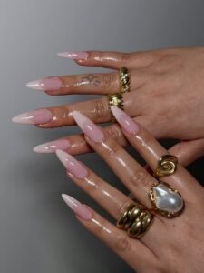 extra long almond shaped nails with milky white french tips and chunky gold rings