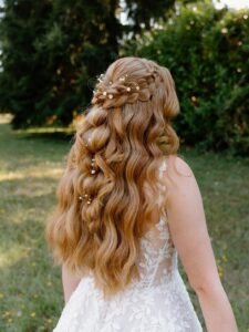 long strawberry blonde wavy hair with a thick side braid and flower accents