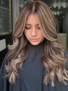 long dimensional blonde hair with soft waves and face-framing highlights