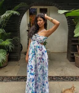 woman wearing a purple and blue floral maxi dress standing in a stone courtyard