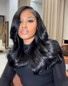 woman with long voluminous black hair styled in bouncy waves