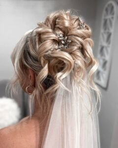 blonde wavy bridal updo with sparkling hair pins and a sheer white veil