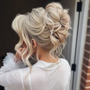 elegant blonde textured bridal updo with loose face-framing curls and pearl hair pins