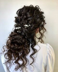 brunette half up half down curly bridal hairstyle with small white flowers