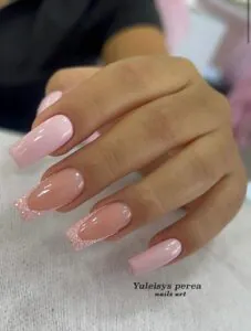 long square light pink nails with pink glitter french tips and glossy finish.