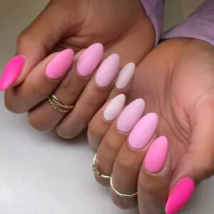 matte almond nails in a gradient of light to bright pink shades.