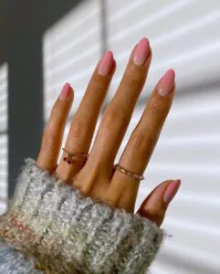 long almond nails with soft pink ombre manicure and gold rings