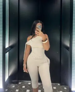 woman in a monochromatic cream outfit featuring an asymmetrical top and matching capri pants.