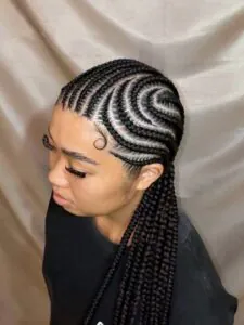 dark cornrows in a swirling pattern on a woman with laid edges