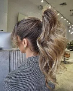 side view of a woman with a high textured ponytail in a salon.