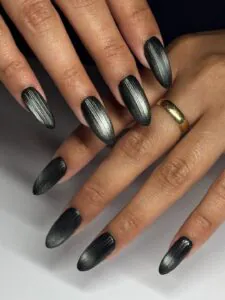matte black almond nails featuring a silver vertical magnetic cat eye stripe.
