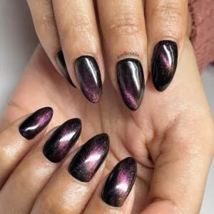 stiletto nails with dark purple and black chameleon cat eye magnetic effect.