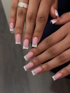 long square french manicure on natural nails with a soft pink base and white tips