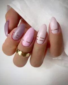 pastel pink and purple almond nails with thin horizontal gold stripes