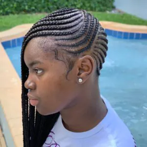 side view of black feed-in braids styled with curved parts near a pool