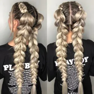 back view of chunky blonde pull through braids styled in double ponytails