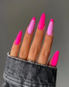 neon pink and matte light pink almond nails with white dotted borders.