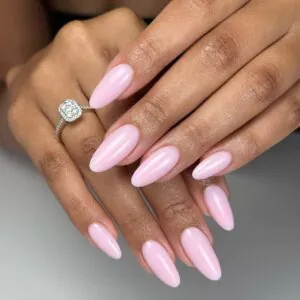 elegant long almond nails with glossy pale pink gel polish and diamond ring.