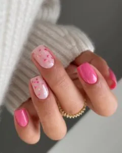 bright pink manicure with light pink accent nails featuring dried floral details.