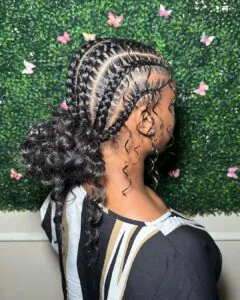 boho stitch feed-in braids styled into a low curly bun with decorative tendrils