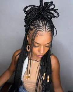 long black fulani braids styled in a large decorative top knot with beads