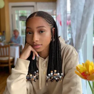 shoulder length fulani braids with clear and brown decorative beads at the ends