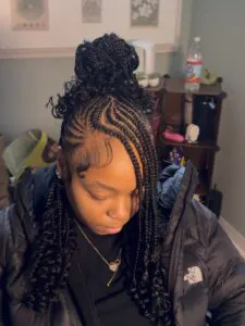 half up half down braided hairstyle with a top bun and curly ends