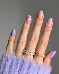 square lilac nails featuring purple floral art and French tips with gold rings