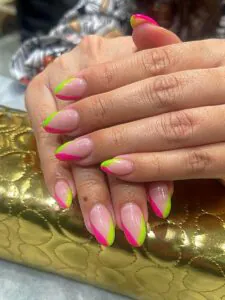 neon pink and lime green diagonal french tip manicure on almond nails