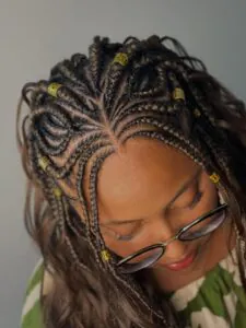 close up of intricate fulani braids with gold cuffs and french curl ends
