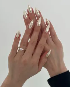 long almond vanilla chrome nails with a pearlescent finish and diamond ring