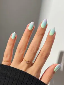 pastel gradient nails in purple blue and green with a gold ring