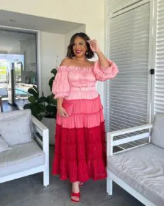 woman in pink and red tiered off-the-shoulder maxi dress standing on a patio