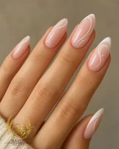 nude oval nails with white swirl line art and tiny crystal accents