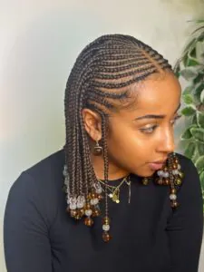woman with short brown fulani braids decorated with clear and amber beads