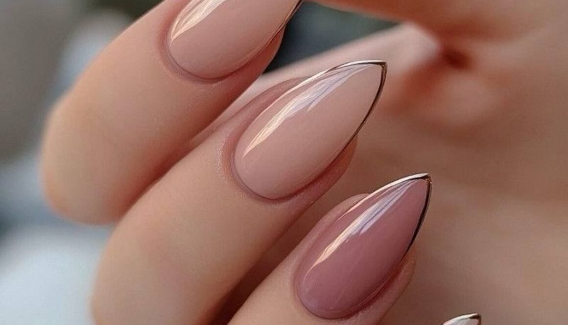 almond shaped nails with nude and mauve ombre polish and thin gold metallic outlines.