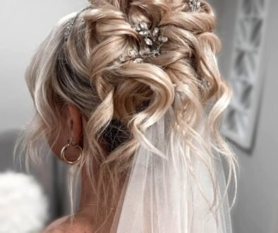 blonde wavy bridal updo with sparkling hair pins and a sheer white veil