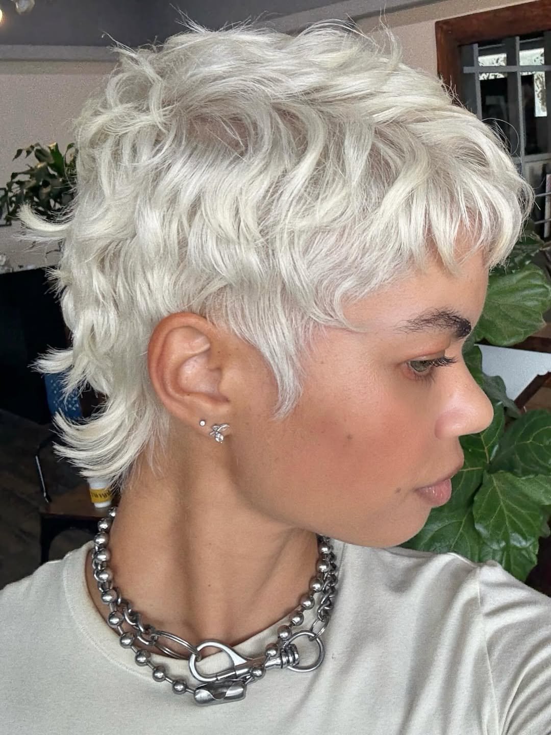 platinum blonde pixie cut with textured layers and side profile view