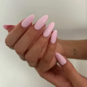 long glossy pastel pink almond shaped gel nails against a plain white background.