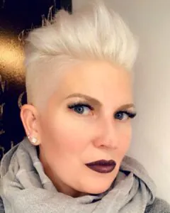 woman with a platinum blonde faux hawk hairstyle and bold dark lipstick