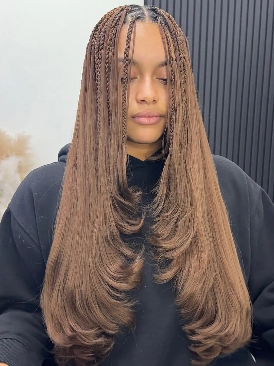 Gemini said woman with long brown boho layered braids featuring sleek straight ends and face-framing plaits.
