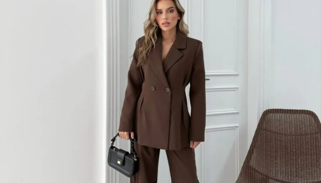 woman wearing a brown double-breasted blazer and matching wide-leg trousers with a black handbag