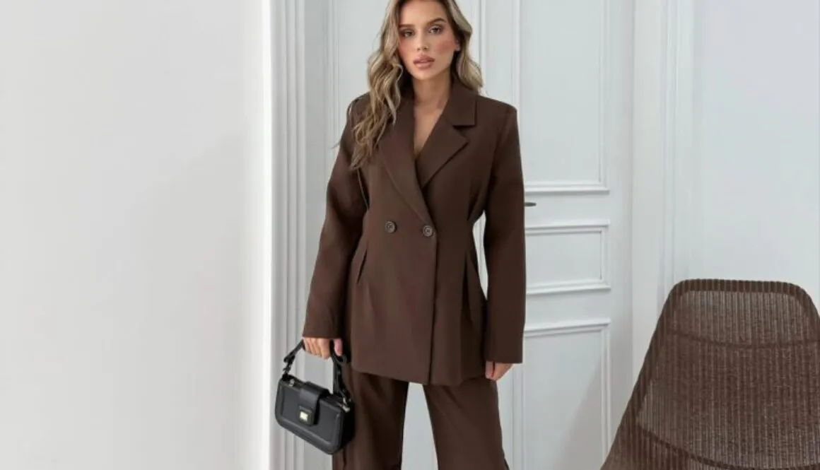 woman wearing a brown double-breasted blazer and matching wide-leg trousers with a black handbag