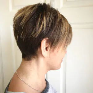 side view of a brown pixie haircut with blonde highlights and undercut
