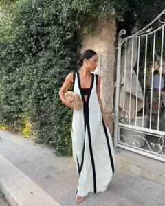 woman in white and black geometric sleeveless maxi dress standing by white iron gate