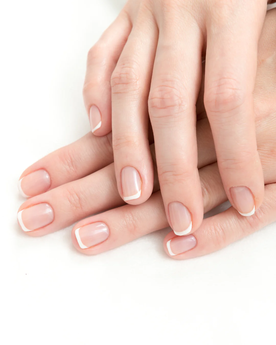 close up of well manicured hands with a classic white tipped french manicure