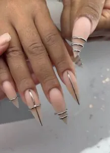 nude stiletto nails decorated with silver metallic rings and vertical line details